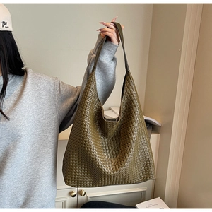 Close-up of olive green woven leather tote bag showing intricate texture and large capacity