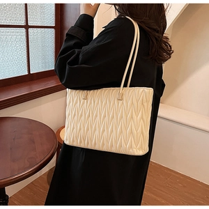 Détail du grand sac cabas beige en similicuir avec matelassage en V et texture souple