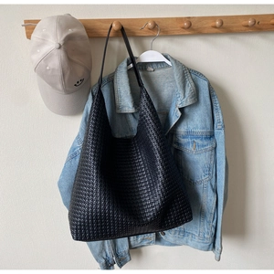 Detail shot of the black woven texture and material on a large capacity hobo tote bag