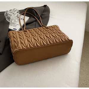 Détails du sac à bandoulière plissé caramel avec texture matelassée et fine lanière
