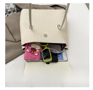 Interior view of off-white woven bucket bag showing capacity for tablet and sunglasses