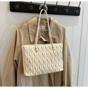 Détail du sac cabas blanc cassé avec surpiqûres ondulées et fine bandoulière