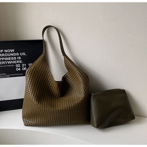 Detail of olive green woven tote bag set with a smooth leather strap and matching pouch