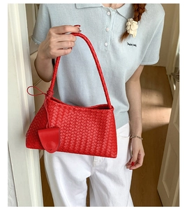 Detail shot of the red woven leather handbag with signature checkered pattern texture