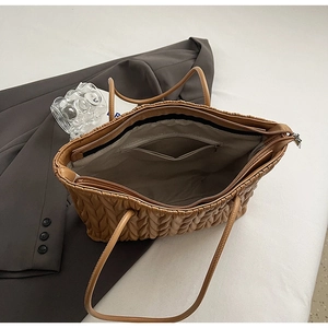 Détail d'un grand cabas camel avec texture en V matelassée, fermeture éclair et poche