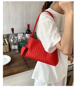 Detail of red woven texture underarm bag with matching circular coin purse charm