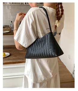 Close-up of black woven leather texture on a minimalist hobo bag with classic craftsmanship