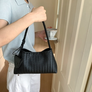 Detail of a black woven leather hobo bag showcasing intricate artisan craftsmanship