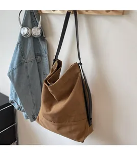 Nahaufnahme einer großen braunen Canvas-Beuteltasche an einem Holzhaken im lässigen Design