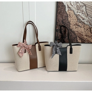 Detailed view of canvas tote bags with leather trim and decorative paisley silk scarves