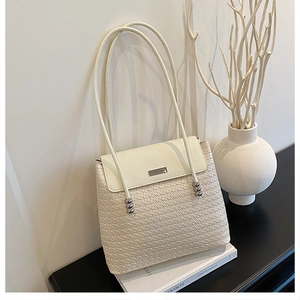 Detail of cream woven shoulder bag with silver metal beads and minimalist texture