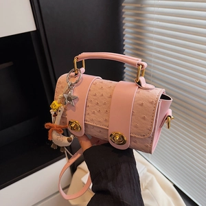 Pink ostrich texture pillow bag with gold locks and cute star charms in soft natural light