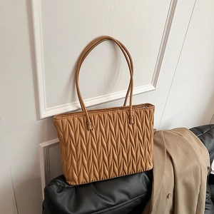 Sac cabas plissé caramel avec longues anses dans un décor intérieur minimaliste