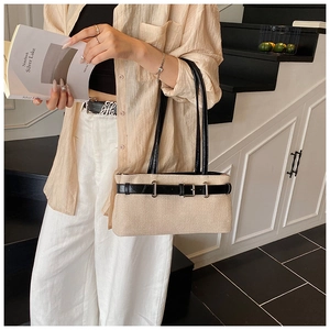 Close-up of contrast canvas bag featuring black leather strap and metal buckle detail
