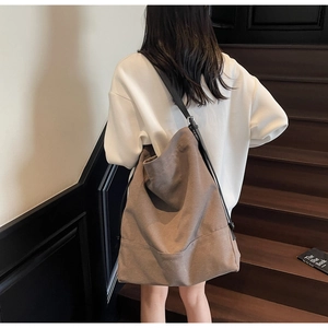 Model wearing a large brown canvas tote bag for daily commute shown from a back view