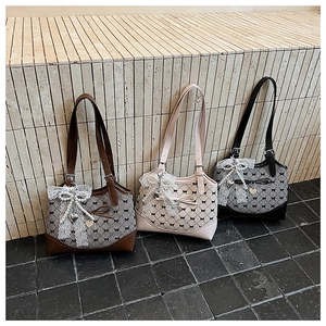 Detailed view of plaid tote bags with lace bows, pearls and heart charms in three colors