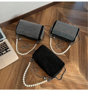 Vue détaillée de trois mini sacs cylindriques en strass avec poignées en perles et chaînes