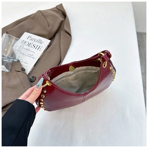 Macro detail of the dark red studded baguette bag interior with zipper pocket