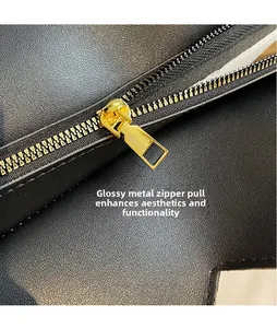 Nahaufnahme des polierten Gold-Reißverschlusses an der schwarzen Leder-Handtasche