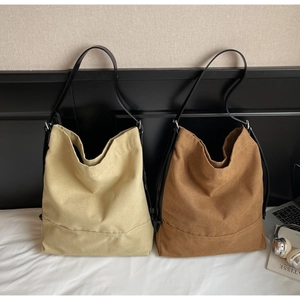 Dettaglio di borse tote in tela beige e caffè con tracolle in pelle in camera