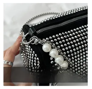 Detail showing the silver metal hook and strap connection on the black pearl handbag