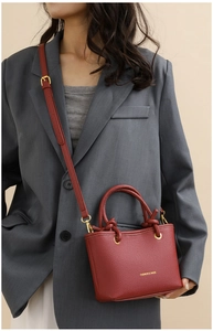 Red lychee grain leather mini bag with gold hardware and logo detail shown on model