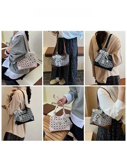 Detail view of stylish bucket bag with lace trim, bow, and heart pendant in three colors