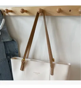 Detail of premium tote bag handle with golden adjustable buckle and leather strap
