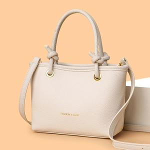 Modern cream litchi texture leather handbag with knotted handles and gold lettering