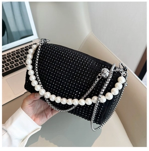 Détail d'un sac de soirée noir en strass avec anse en perles et chaîne en métal
