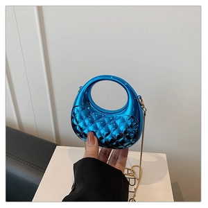 Detail of blue acrylic mini bag featuring quilted texture and round handle with gold chain