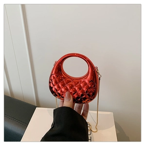 Detail of red metallic acrylic mini bag with quilted texture and golden chain strap