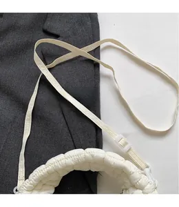 Close-up of the smooth adjustable shoulder strap on a beige quilted crossbody bag