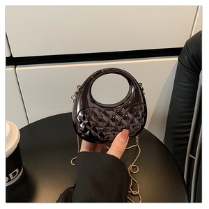 Close-up of gunmetal acrylic bag with diamond lattice pattern and gold chain strap