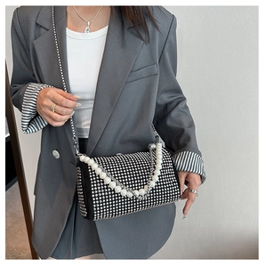 Détail d'un sac bandoulière tendance avec strass scintillants et une grande chaîne perles