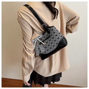 Detailed view of women's crossbody bag with lace bow decoration and pearl pendant