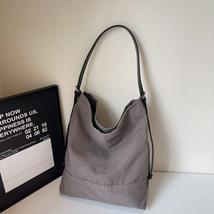 Borsa tote minimalista in tela grigia con tracolle in pelle in un interno di design chic