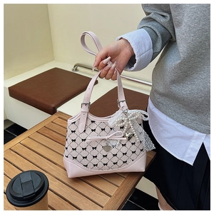 Détail du sac cabas à carreaux roses avec nœuds noirs et breloque en dentelle de perle