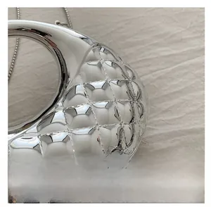 Macro shot of silver mirrored crescent bag with diamond quilted texture and metal chain