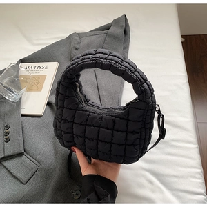 Detail of black quilted puffer bag with hobo silhouette and detachable shoulder strap