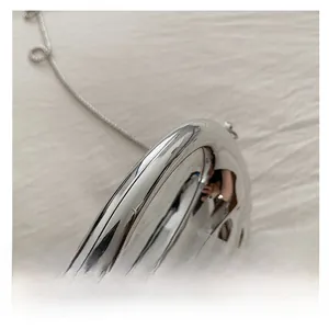 Close-up of metallic silver acrylic box bag showing mirror finish and chain strap