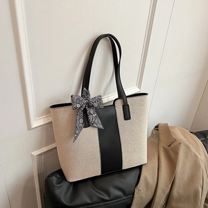 Modern two-tone canvas tote bag with black leather straps and decorative floral scarf