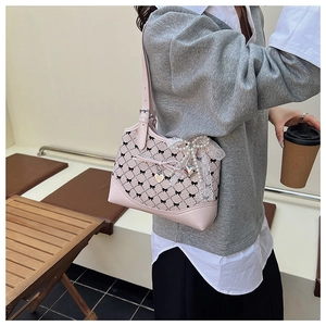 Détail du sac sous l'aisselle à carreaux roses avec dentelle, perles et pendentif