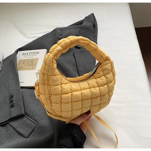 Detail of yellow quilted bubble handbag with soft grid texture and zipper closure