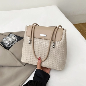 Beige woven leather tote bag with silver metal ball clasp and thin shoulder strap