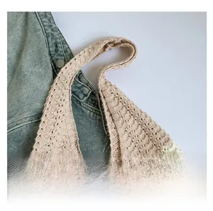 Close-up of wide knitted shoulder strap and texture of floral woven tote bag