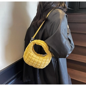 Detailed view of yellow quilted cloud bag with textured finish and slim shoulder strap
