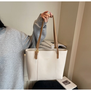 Detailed close-up of cream tote bag with thin brown straps and Fashion & Bags text