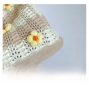Close-up of bohemian crochet knit tote featuring handmade yellow and orange 3D flowers