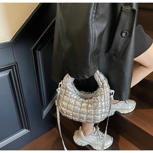 Close-up of metallic silver cloud bag with quilted pattern and sleek metal zipper detail